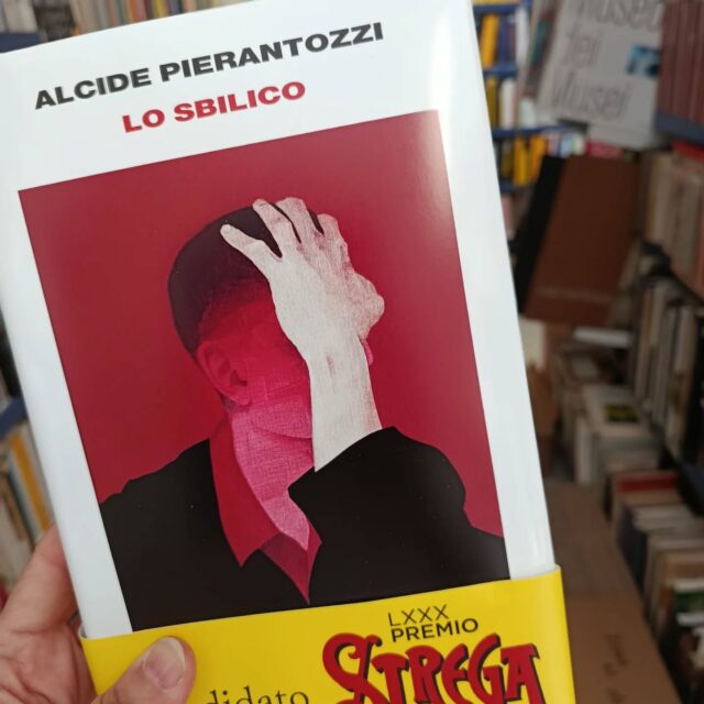 "Lo sbilico"
di Alcide Pierantozzi
Einaudi editore
Finalista al Premio Strega 2026
«Il problema era che io aspettavo i corvi, e invece arrivavano i pensieri». Cosa accade quando la realtà si smaglia, e lascia entrare l'allucinazione? Quando la paura ti avvinghia e si accorcia il respiro? Quando l'unico modo che hai per stare al mondo è vivere su un precipizio, nello «sbilico» delle cose? Alcide Pierantozzi si è immerso in quel precipizio, e ne è uscito stringendo tra le mani un libro unico, letterario e ossessivo, capace di raccontarci per la prima volta in modo crudo e vero, “da dentro”, un male che è di molti. Una storia di una potenza disarmante, che urtica e lenisce insieme, e che una volta iniziata pretende di essere letta fino all'ultima parola. O bevuta fino all'ultima goccia, come una medicina. Alcide ha quarant'anni, a volte dorme ancora con sua madre, prende sette pasticche al giorno (cinque la mattina e due dopo cena), ed è considerato «un paziente lucido, vigile, collaborativo, dall'eloquio fluido». È un essere umano «difettoso» tra i tanti, ma i suoi difetti stanno tutti dentro quattro pagine di diagnosi controfirmate da uno dei più famosi psichiatri italiani: «disturbo bipolare», «spettro dell'autismo», «dissociazione dell'io», «antipsicotici», «pensieri di mancata autoconservazione»... Dal suo esilio in una cittadina dell'Abruzzo, dove ogni cosa sembra da sempre uguale a sé stessa, Alcide ci racconta il tempo melmoso delle sue giornate. Le ore in spiaggia, o a sfinirsi in palestra, dove va per riguadagnare in muscoli quello che ha perso in lucidità mentale. Soprattutto ci racconta – con tutta la chimica che ha in testa – cosa accade quando l'equilibrio psichico s'incrina: l'innesco della paranoia, la percezione che si sdoppia, il modo in cui il tempo fermo di un'attesa non è mai davvero fermo, perché è lì che arrivano i pensieri.
#losbilico #alcidepierantozzi #einaudieditore #finalistapremiostrega2026