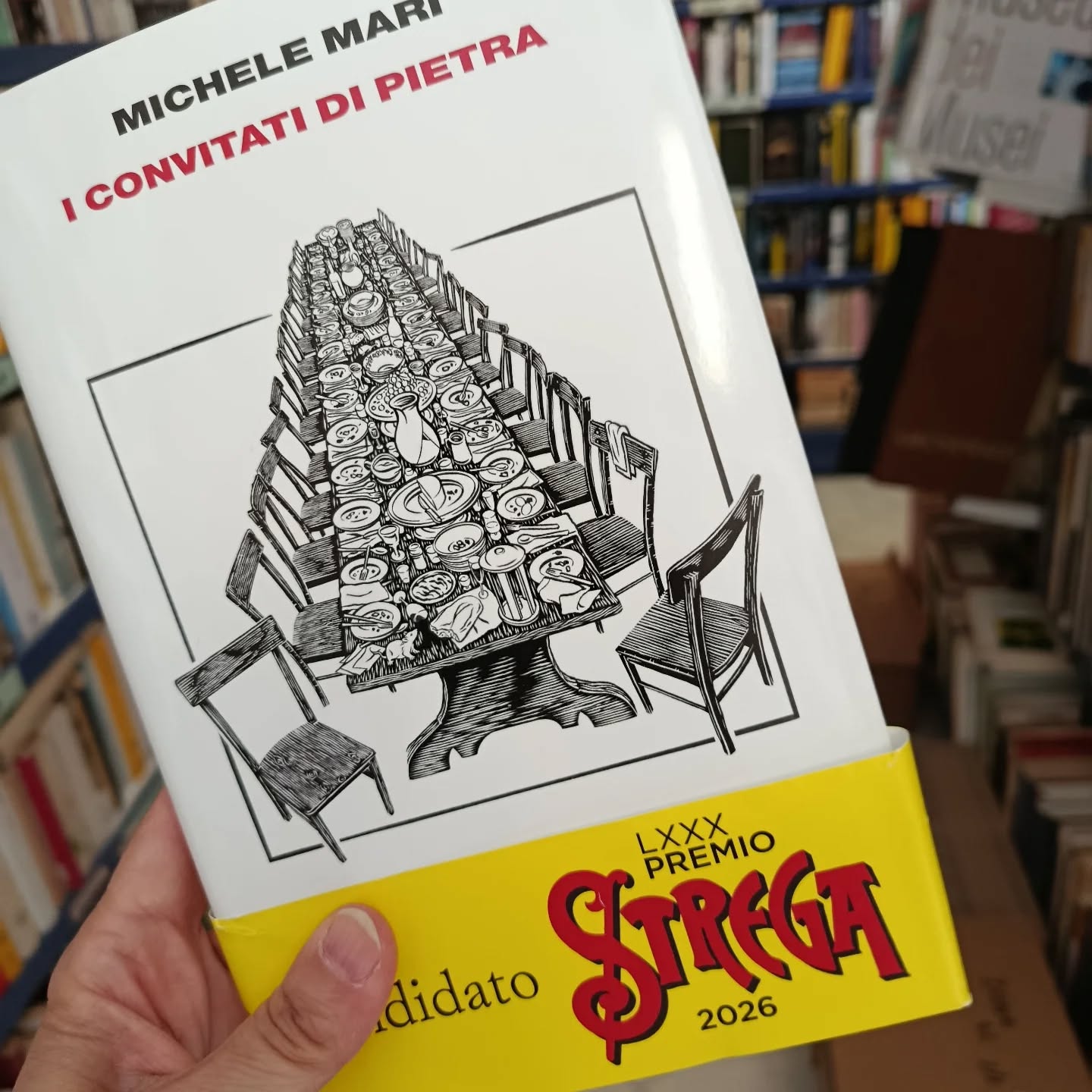 "I convitati di pietra"
di Michele Mari
Vincitore del Premio Strega Giovani
Davvero il destino di ciascuno di noi è già scritto? È questo che pensano gli ex alunni della III A quando, superato l’esame di maturità, siglano il «patto sciagurato» che li vincolerà fino all’ultimo giorno. Del resto il tempo della scuola è l’unico a rimanere immobile: anche dopo trent’anni non saranno le rughe o i chili in più a contraffare la sagoma di un vecchio compagno di banco. Ma quando di mezzo ci sono il demone della competizione e il miraggio di un premio favoloso le variabili si moltiplicano. E così un accordo nato quasi per scherzo si tramuta in una sfida senza esclusione di colpi per rimanere in vita il più possibile. Michele Mari ha scritto un romanzo commosso e giocoso, svelando con perfido divertimento le pulsioni che si nascondono dentro l’amicizia. Perché in questa storia, prima di un imprevedibile finale, vale il contrario di quanto recita il proverbio: chi perde un amico trova un tesoro. 22 luglio 1975: la data fatidica in cui una classe del liceo, festeggiando con una cena il primo anniversario dell’esame di maturità, decide di stipulare un accordo di sangue e denaro. Ognuno dei trenta ex alunni verserà tutti gli anni una cifra, e il capitale sarà investito in modo da generare – col trascorrere dei decenni – un’autentica fortuna. Il meccanismo è semplice: la riffa terminerà quando saranno rimasti in vita soltanto tre compagni di classe, e a quel punto i superstiti potranno godere del montepremi… Ma i rancori sopiti, gli amori taciuti, le promesse e le invidie nate sui banchi di scuola s’infiammano un anno dopo l’altro. E quando ogni 22 luglio si rivedranno a cena, si informeranno dei malanni altrui per prevedere il prossimo di loro che passerà a miglior vita. Fino a trasformare i protagonisti di questa storia in giocatori seduti al tavolo di un’immaginaria roulette, «per i quali indovinare un numero significa desiderarlo, se non altro per poter continuare a giocare».
#michelemari #iconvitatidipietra #einaudieditore #premiostregagiovani2026